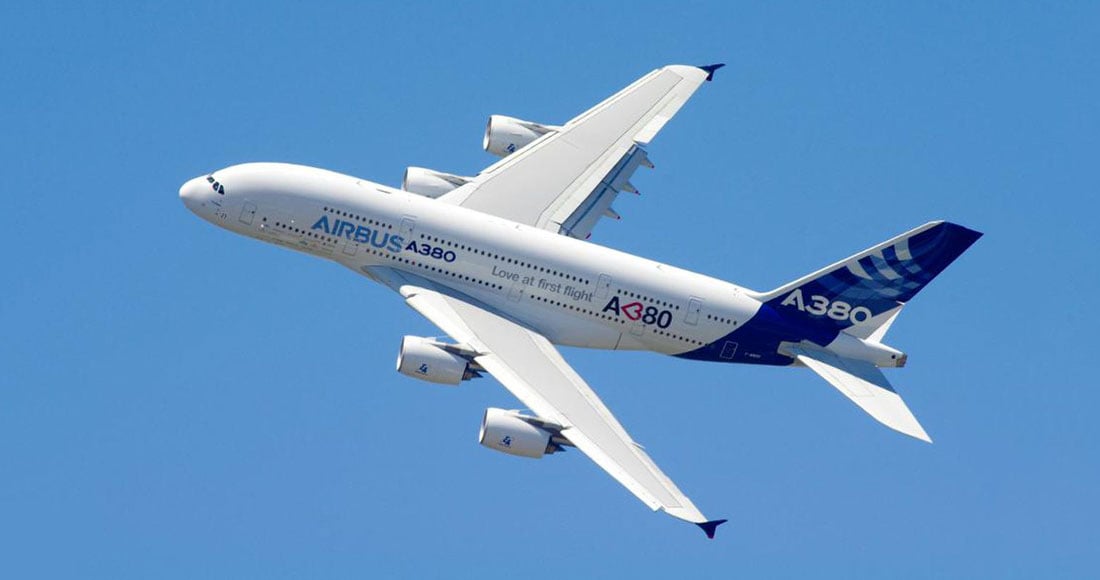 Airbus A380 soars, wings angled.
