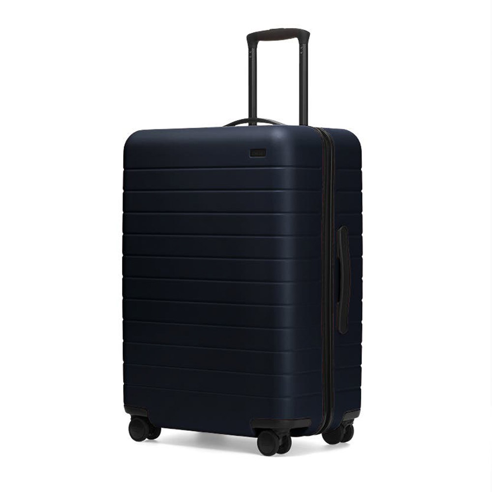 Stylish dark blue hard-shell suitcase with wheels.