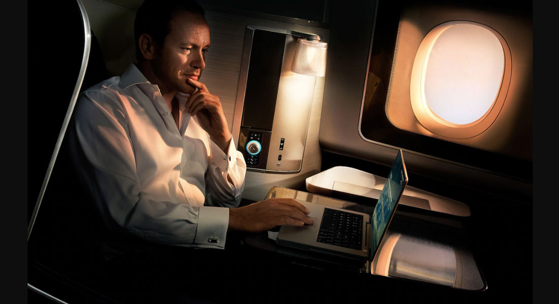 Man works on laptop mid-flight.