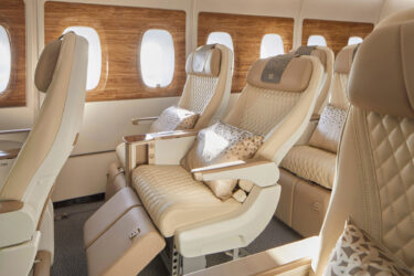 Luxury airplane cabin: leather seats, wood accents.