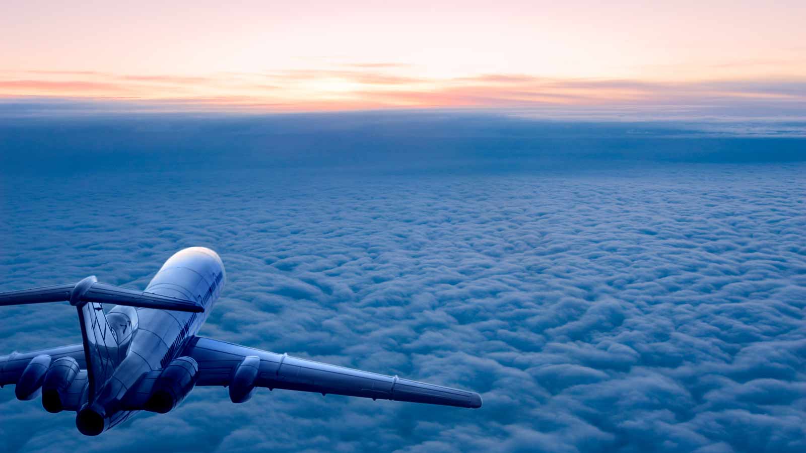 Airplane glides at sunset; serene, silhouetted wings.