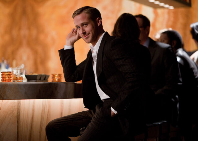 Man in pinstripe suit relaxes at bar.