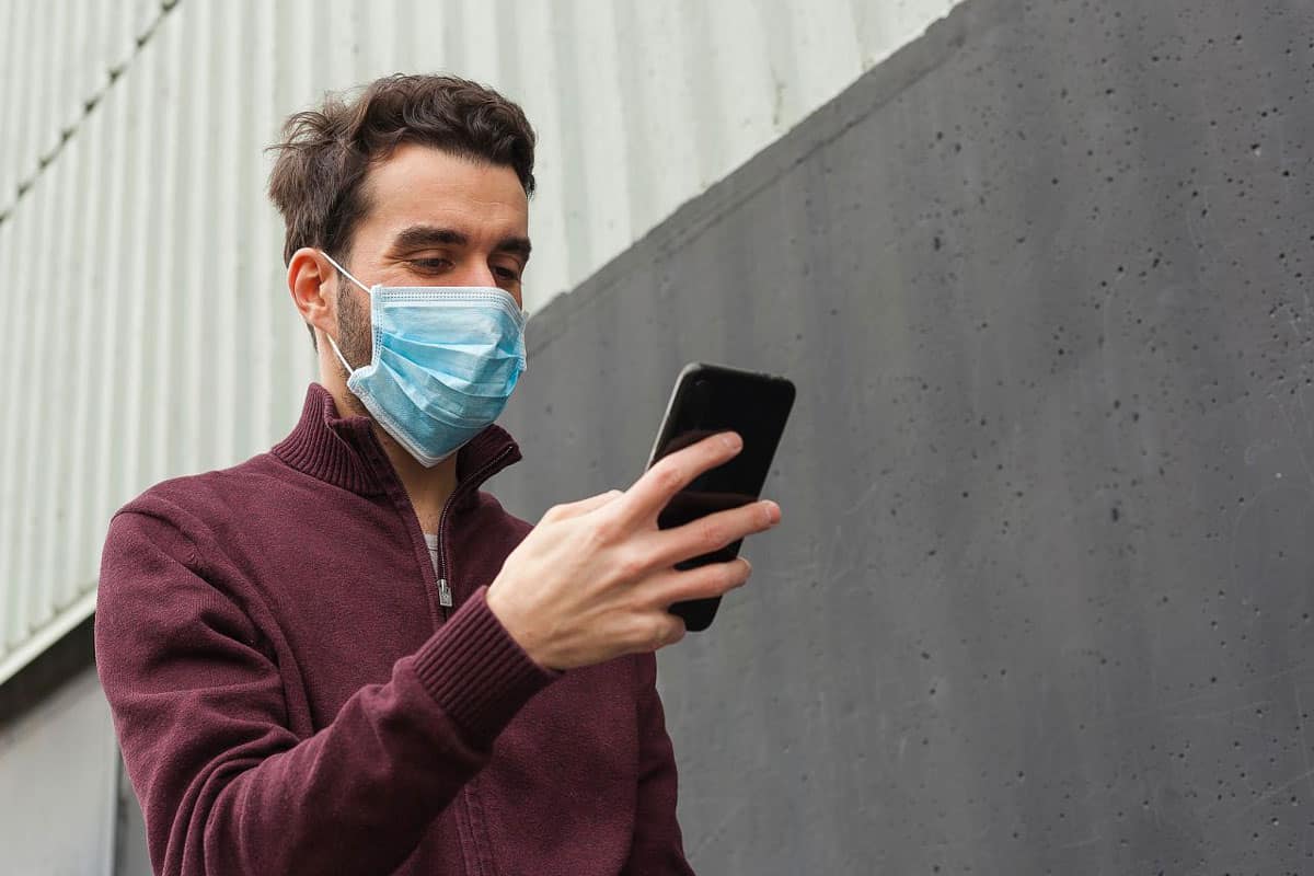 Man in mask, smartphone, Etihad.