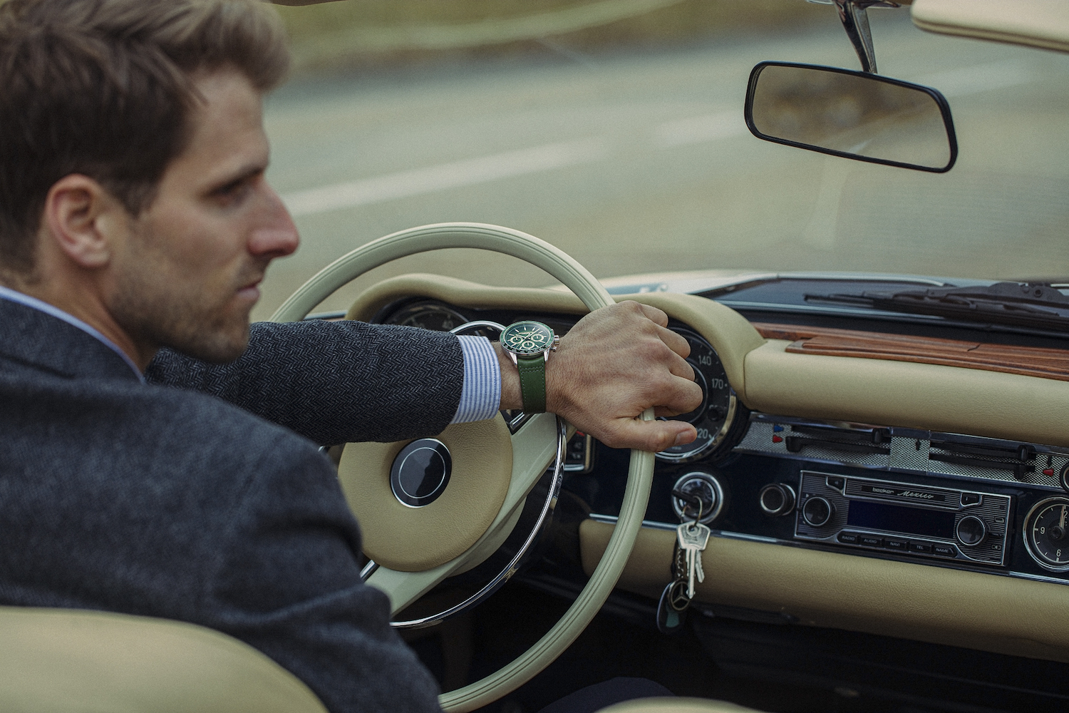 Man in vintage car wearing Raymond Weil watch.
