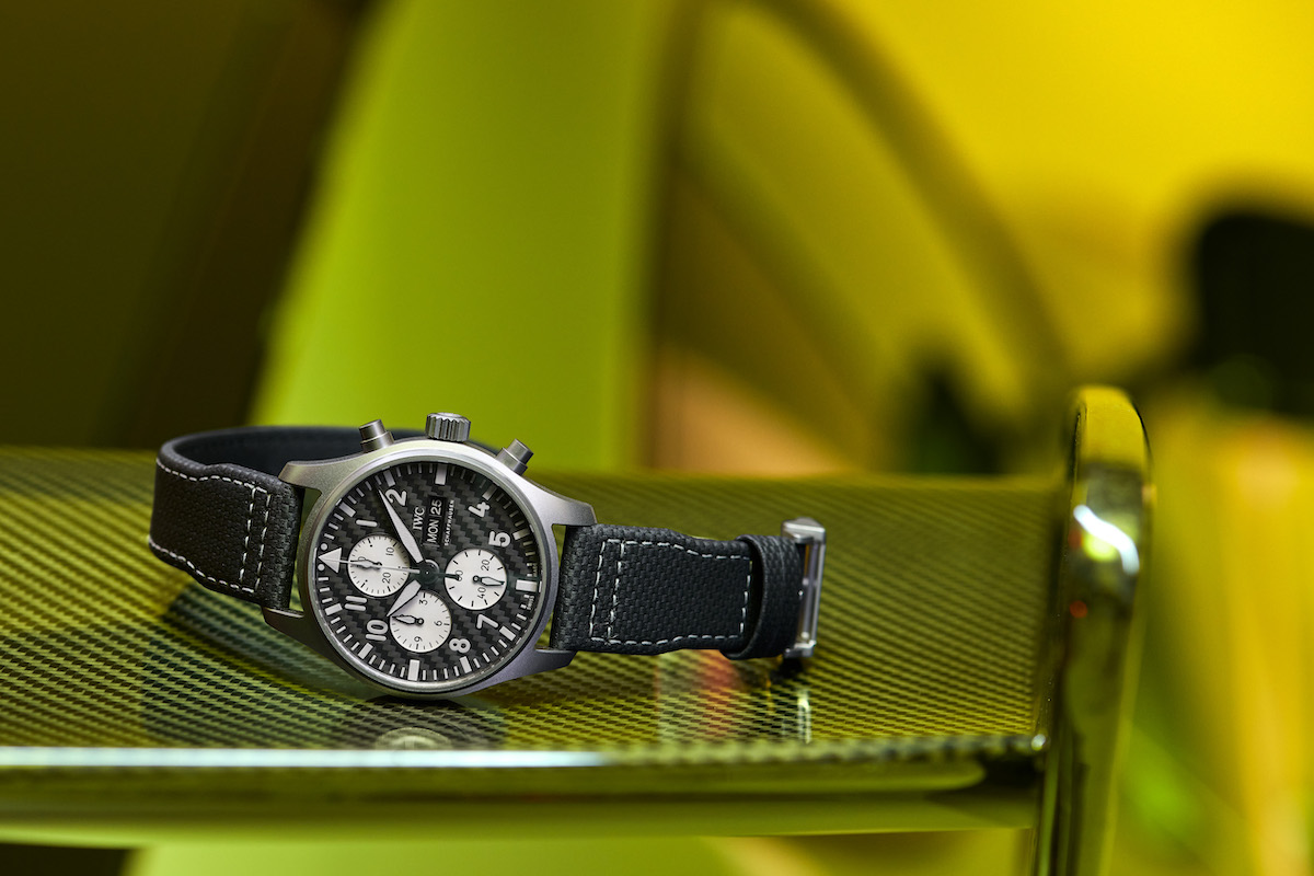 Black IWC watch on carbon fiber surface.