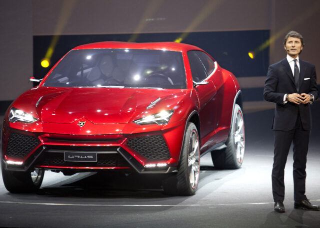 A man introduces a red Lamborghini SUV.