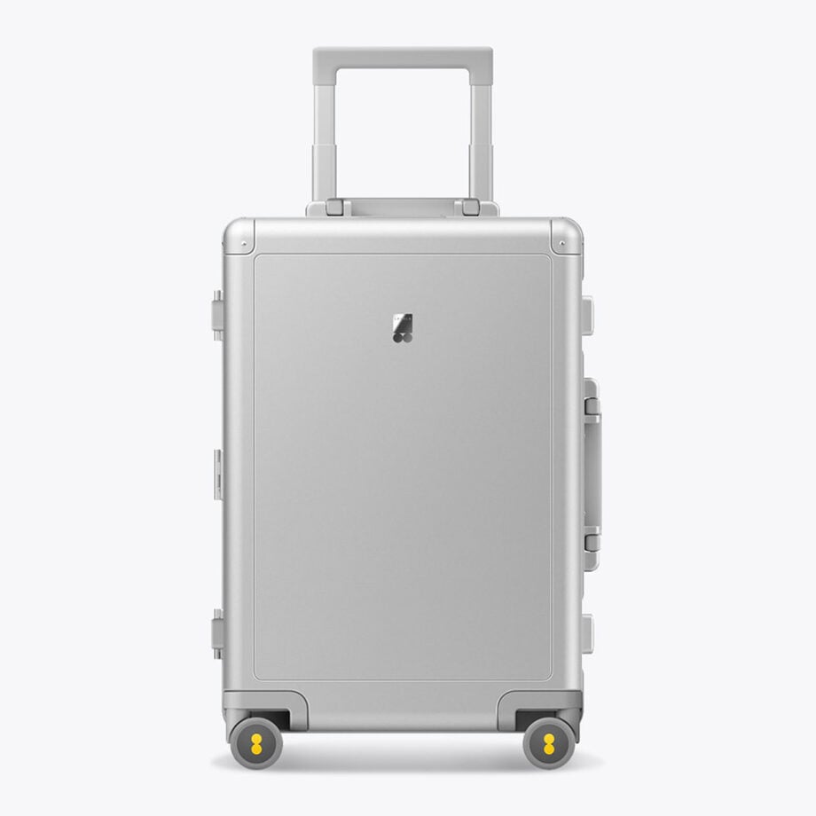Minimalist silver suitcase with yellow-accented wheels.