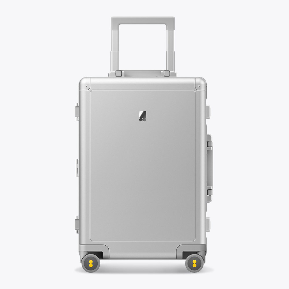 Minimalist silver suitcase with yellow-accented wheels.