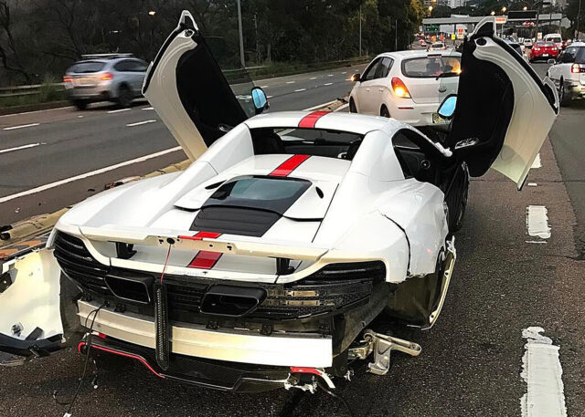 White McLaren with red stripe, damaged rear.
