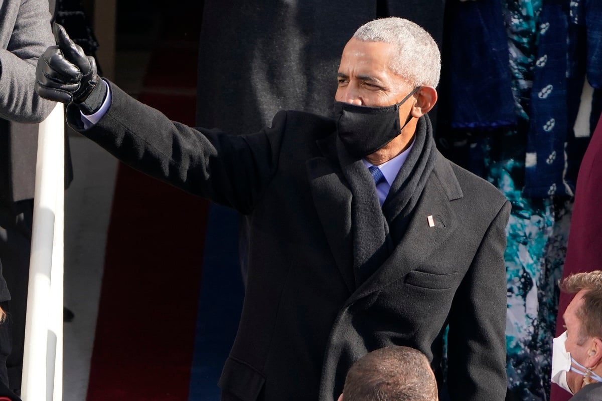 A masked man waves, wearing a Rolex.