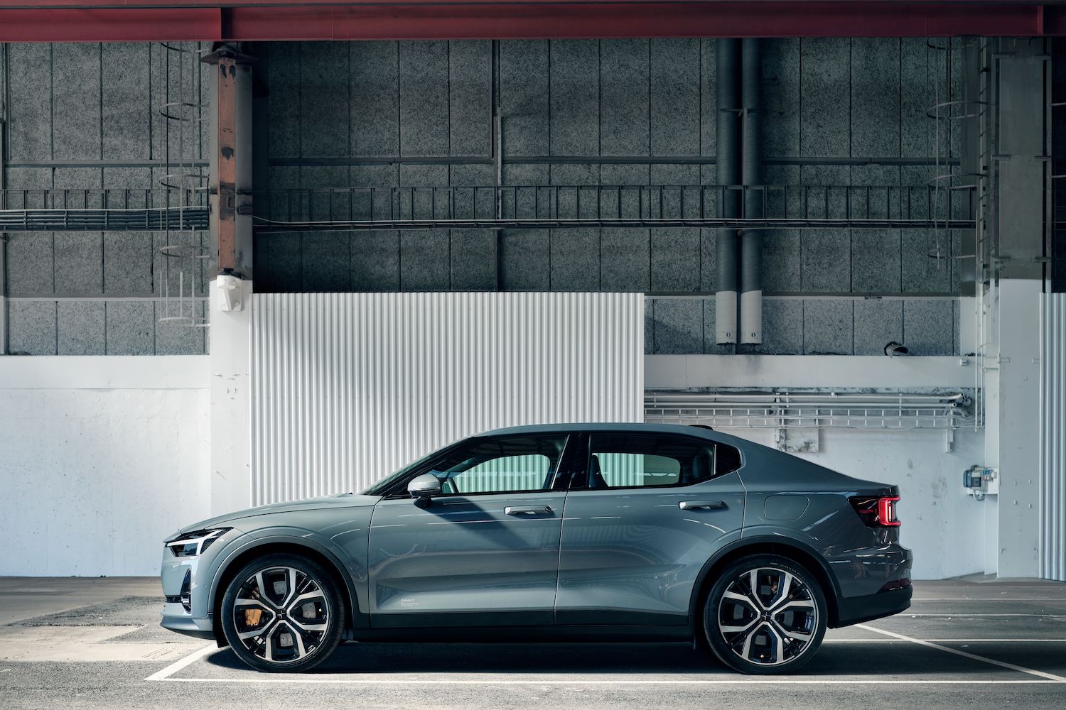 A Polestar 2 sedan parked industrially, stylishly.