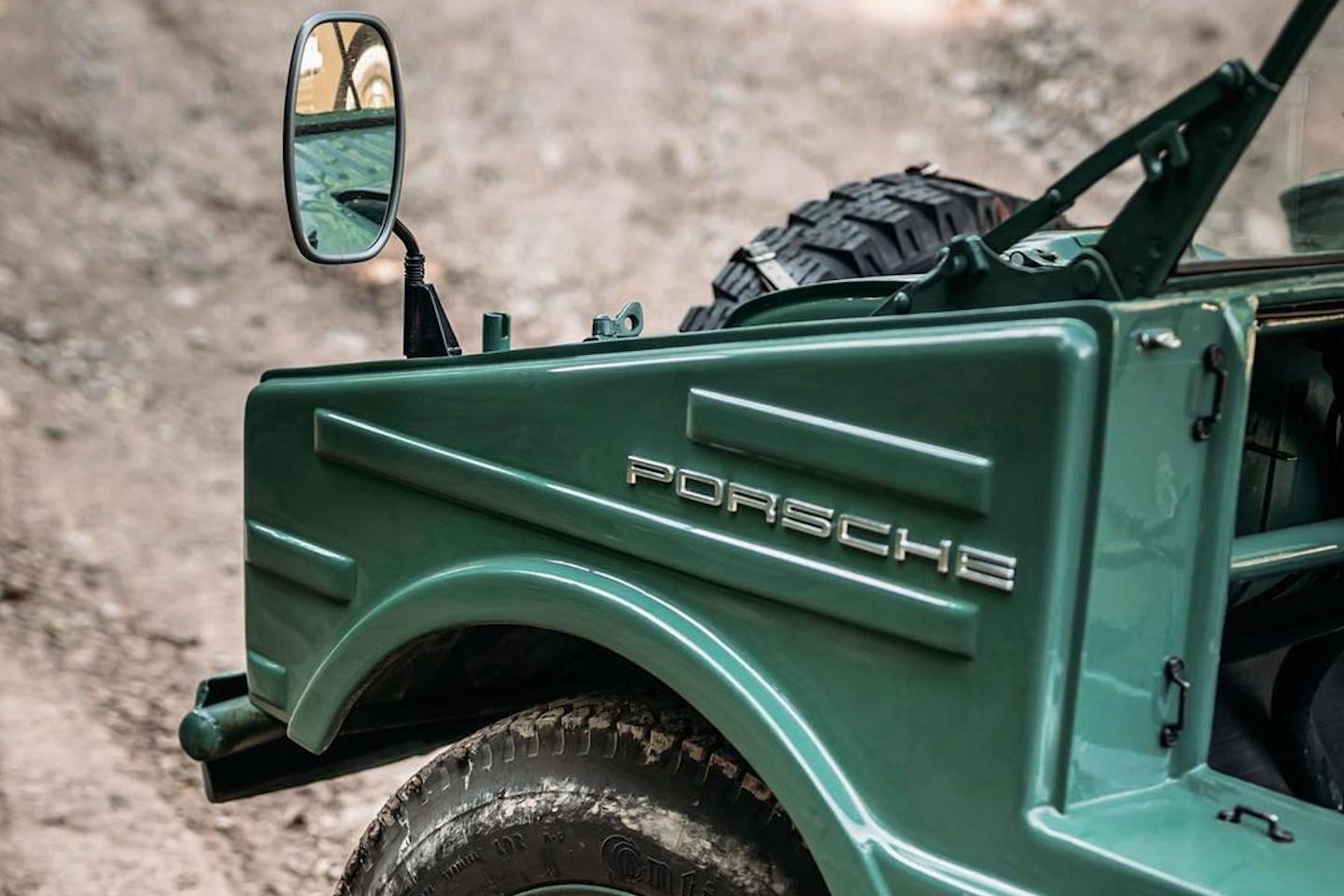 Green Porsche off-road vehicle with emblem visible.