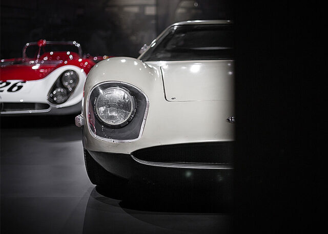 Classic white sports car with vintage race car.