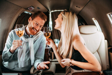 Couple enjoys wine aboard luxury private jet.