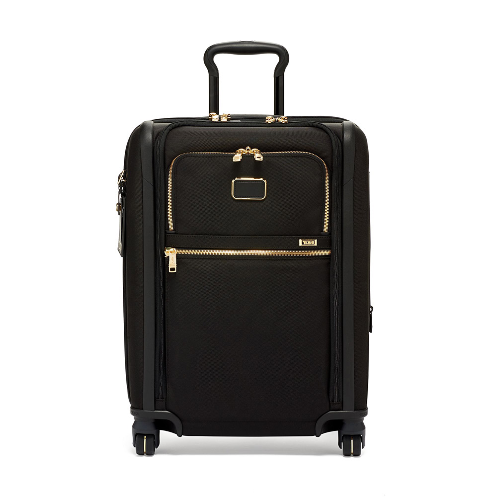 A black suitcase with gold zippers, four wheels.
