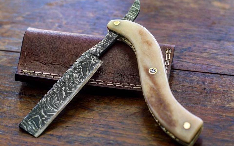 A straight-edge razor on a leather case.