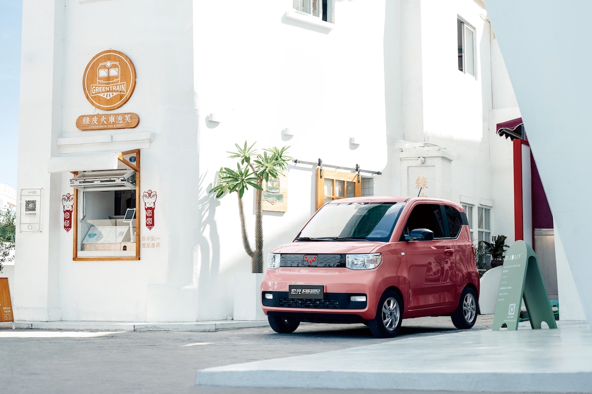 Red Wuling Hongguang Mini EV outside GREENTAN building.